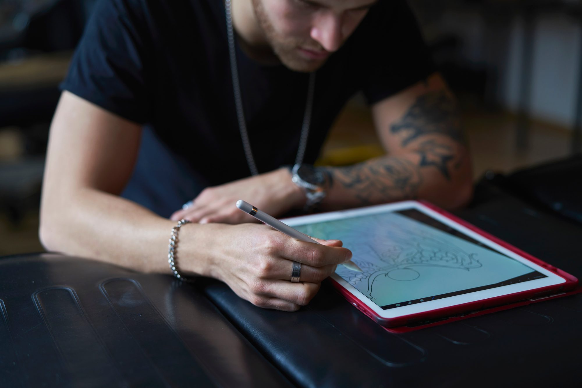 Tablet üzerinde dövme tasarımı çizen bir sanatçı